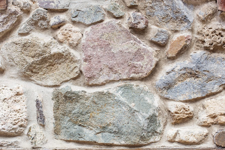 Grey and brown grunge stone wall background texture. Old masonry on the walls of houses