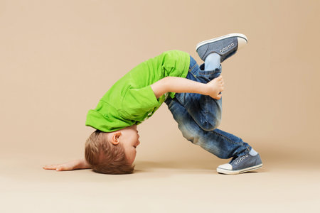 break dance kids. little break dancer showing his skills in dance studio. Hip hop dancer boy...