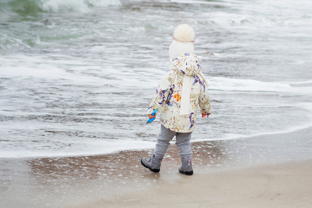 Cute little girl playing on the sandy beach.の写真素材