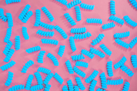 Top view of blue fusilli pasta on the bright pink background. Fashion food. Abstractの写真素材