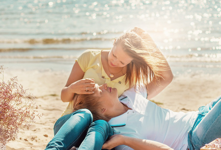 happy young couple enjoying picnic on the beach and have good time on summer vacationsの写真素材