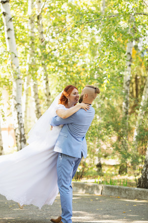 Just married loving hipster couple in wedding dress and suit in the park. Happy bride and groom walking running and dancing. Romantic Married young family. Autumn weddingの写真素材