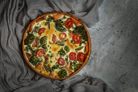French pie Quiche or Quiche lorraine - traditional open pie with salmon, broccoli, egg, cheese, tomato.の写真素材