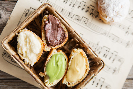 Homemade profiteroles on the music sheet with notes. Profiteroles (choux Ã  la crÃ¨me) - French...