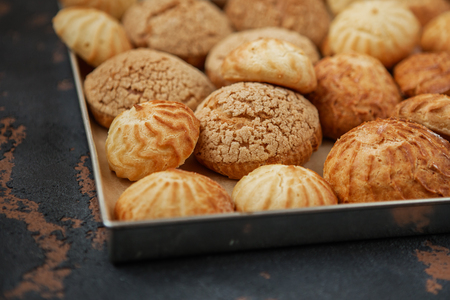 Homemade profiteroles on the music sheet with notes. Profiteroles (choux Ã  la crÃ¨me) - French choux pastry balls filled with custard or cottage cheese sprinkled with powdered sugarの写真素材