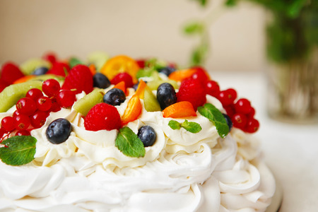 Pavlova cake with cream and fresh summer berries. Close up of Pavlova dessert with forest fruit and mint. Food photography macroの写真素材