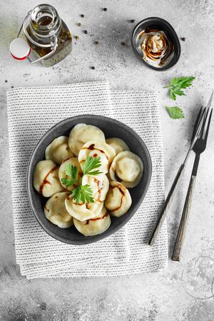 Meat dumplings - russian pelmeni, ravioli with meat on a grey bowl. Flat lay composition. Food photographyの写真素材