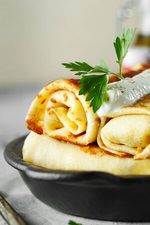 Thin pancakes with fillings. tasty stuffed pancakes crepes with cabbage closeup. Russian Fried Stuffed Pancakes Blintzes with cabbage. Food photography.の写真素材