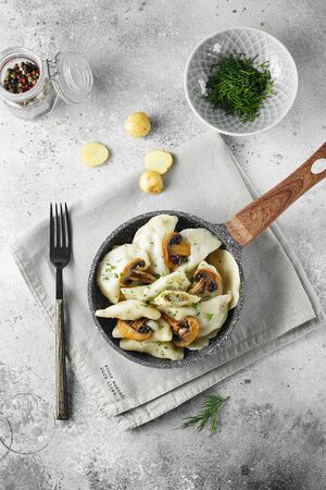 Dumplings, filled with mashed potatoes and mushrooms on little frying pan. Russian, Ukrainian or Polish dish: varenyky, vareniki, pierogi, pyrohy. Food photography. Flat layの写真素材
