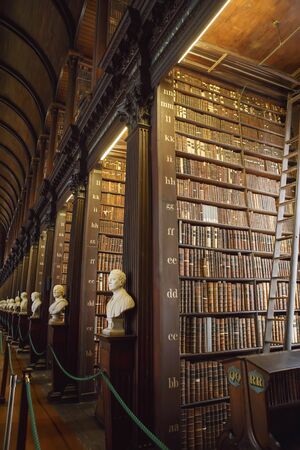 Dublin, Ireland - June 24, 2019: The Long Room interior Of The Old Library At Trinity College. Marble busts of great people and shelves with antique tomesのeditorial素材