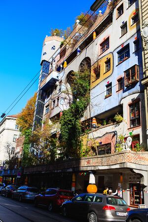 Vienna, Austria - October 27, 2019: Hundertwasserhaus apartment block has colorful facade, undulating floors, roof covered with earth and grass, large trees growing from inside the roomsのeditorial素材