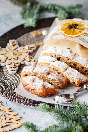 Holiday baking. Christmas cake. Stollen is fruit bread of nuts, spices, dried or candied fruit, coated with powdered sugar. It is traditional German bread eaten in the Christmas season. New year prepの写真素材
