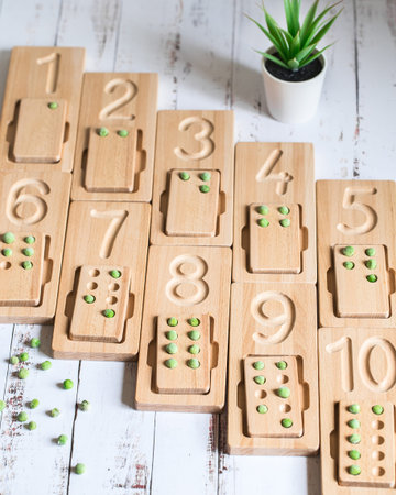 Wooden counting and writing trays with green peas for educating littles on number writing, fine...