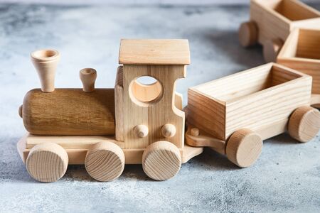 Children's wooden toys. Children wooden train with wagons. Natural wood construction set. Educational equipment. Children's wooden locomotive with various cargo in wagons.の写真素材