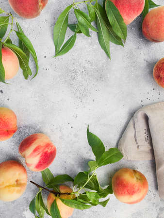 Several ripe juicy peaches on a gray background. Peach fruits on the wooden board. Green living concept. Organic food.の写真素材