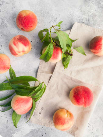 Several ripe juicy peaches on a gray background. Peach fruits on the wooden board. Green living concept. Organic food.の写真素材