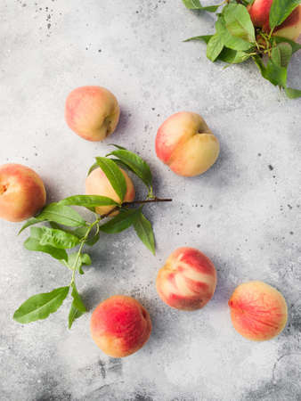 Several ripe juicy peaches on a gray background. Peach fruits on the wooden board. Green living concept. Organic food.の写真素材