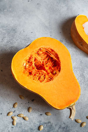 Fresh butternut squash on the gray background. Butternut Pumpkin. Halves of raw orange pumpkin. Contrast photo. Healthy Meal Prep, recipe preparation photos. Seasonal pumpkin cookingの写真素材