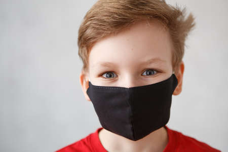 Little boy wearing a mask against corona virus covid-19, 2019-nCov. Kid in a surgical bandage or respirator during corona virus and flu outbreak. Child in a medical mask. Coronavirus quarantine.の写真素材