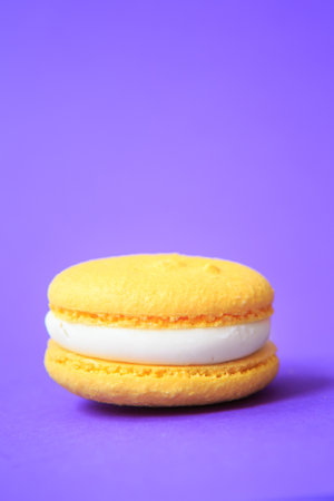 yellow Cake macaron or macaroon on purple background. colorful almond cookies. French macaroon cake close-up. Macaroons on colored backgroundの写真素材