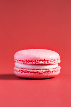 pink Cake macaron or macaroon on red background. colorful almond cookies. French macaroon cake close-up. Macaroons on colored backgroundの写真素材