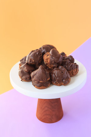Homemade profiteroles with chocolate. Cream puffs filled chocolate vanilla custard on a bright...