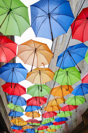 Umbrellas exhibition, street decorated. the sky is filled with colorful umbrellas. Many colorful umbrellas against the sky in city settings. color backgroundの写真素材