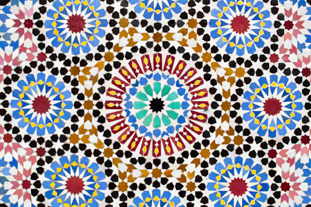 A detailed Islamic geometric mosaic featuring vibrant colors and symmetrical patterns. The design showcases traditional arabesque motifs with star shapes and interwoven linesの写真素材