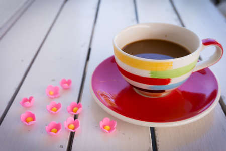 Coffee cup with small flowers on wooden tableの写真素材