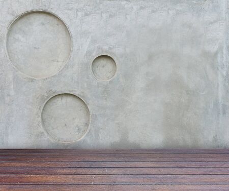 wood floor and gray concrete wall with circle pitted texture backgroundの写真素材