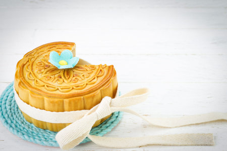 Decorated Chinese mooncake on white wood background