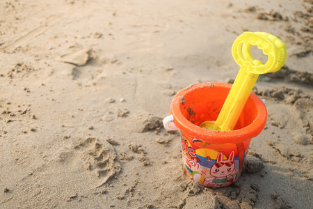 Plastic toy bucket on the sand beachの写真素材