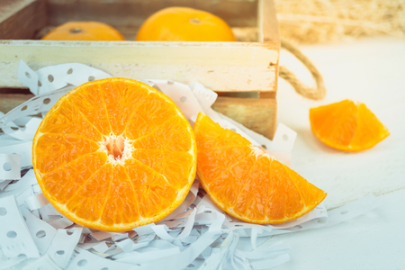 Oranges, close up whole orange fruits and sliced orange on wood backgroundの写真素材