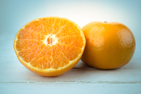 Oranges, close up whole orange fruit and sliced orange on wood backgroundの写真素材