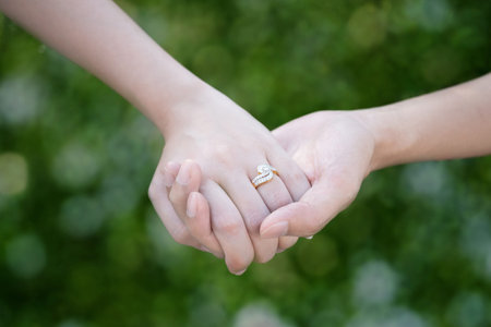 Lovers couple holding hands with bokeh background for friendship and love conceptの写真素材