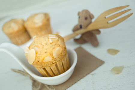 Homemade banana cup cake with sliced almond on wood background
の写真素材