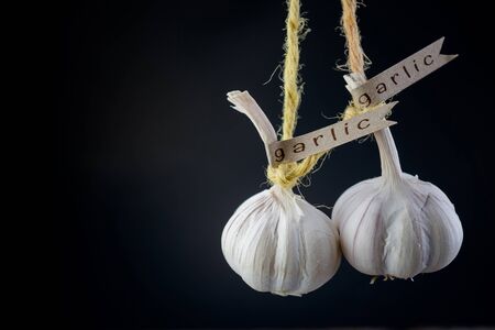 Decorated garlic bulb hanging on black backgroundの写真素材
