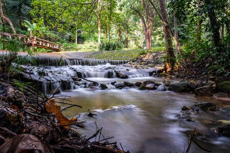 Small waterfall  with old wooden  bridgeの写真素材