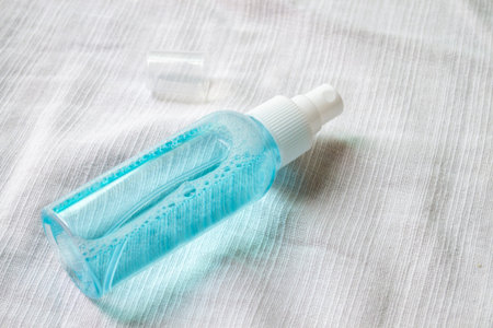 Alcohol spray bottle on a white fabric backgroundの写真素材