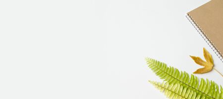 Flat lay, Office desk working space with notepad, leaf and notebook.Top view with copy space for text or image.background working desk concept.の写真素材