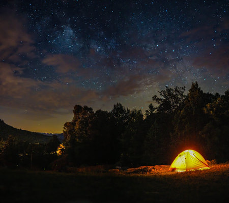 A camping tent is under milky way sky and twilight at night in Horseshoe Canyon Ranch, Jasper...