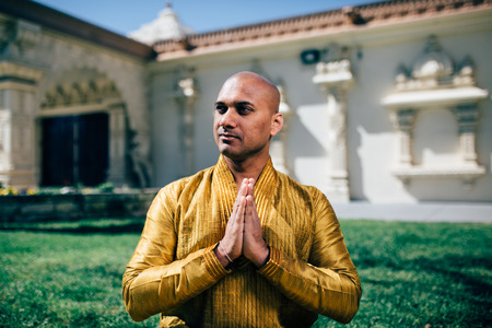 Handsom Indian Man Greeting Namaste, in Gold Kurta at the Templeの写真素材