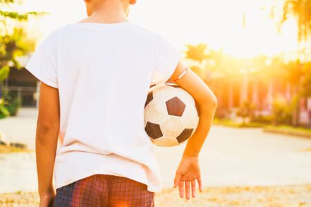 kids are playing soccer football for exercise under the sunlight.の写真素材