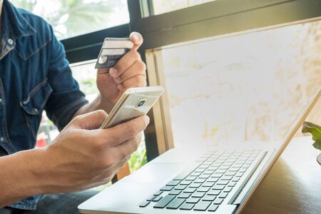 Online payment,Man's hands holding smart phone for online shoppingの写真素材