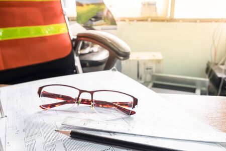 Close up desk of engineer with diagram for fiber optic core assignment, morning light