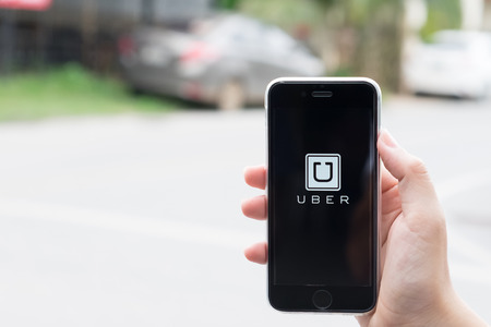 CHIANG MAI,THAILAND, JUL - 24 -2016 : male hands holding iPhone 6 plus showing Uber app on screen ,Uber is smartphone app-based transportation network.のeditorial素材