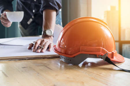 Image of engineer holding a cup of coffee and check blue print. selective focusの写真素材
