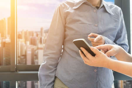 business partners use smart phone discussing documents and ideas at meeting
