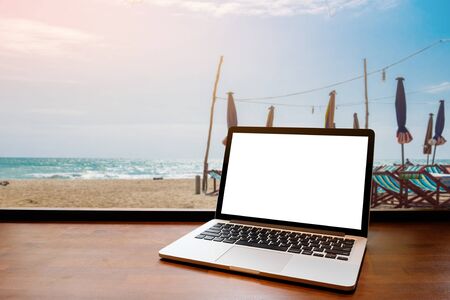Laptop with blank screen on table. beach backgoundの写真素材