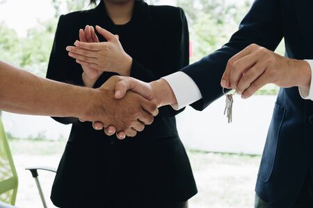 Estate agent shaking hands with his customer after contract signature and congratulationの写真素材